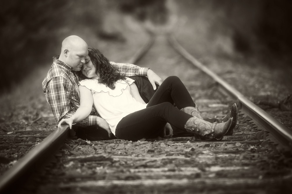 engaged couple on railroad tracks